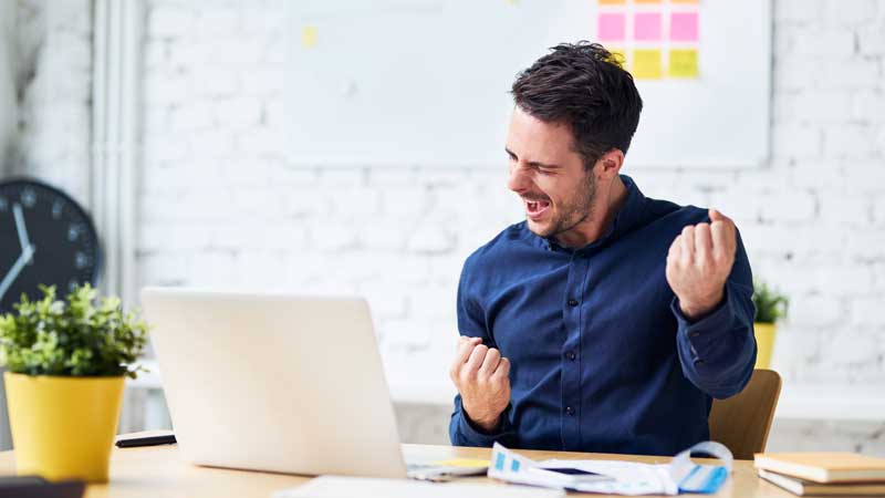 A man excited at his desk