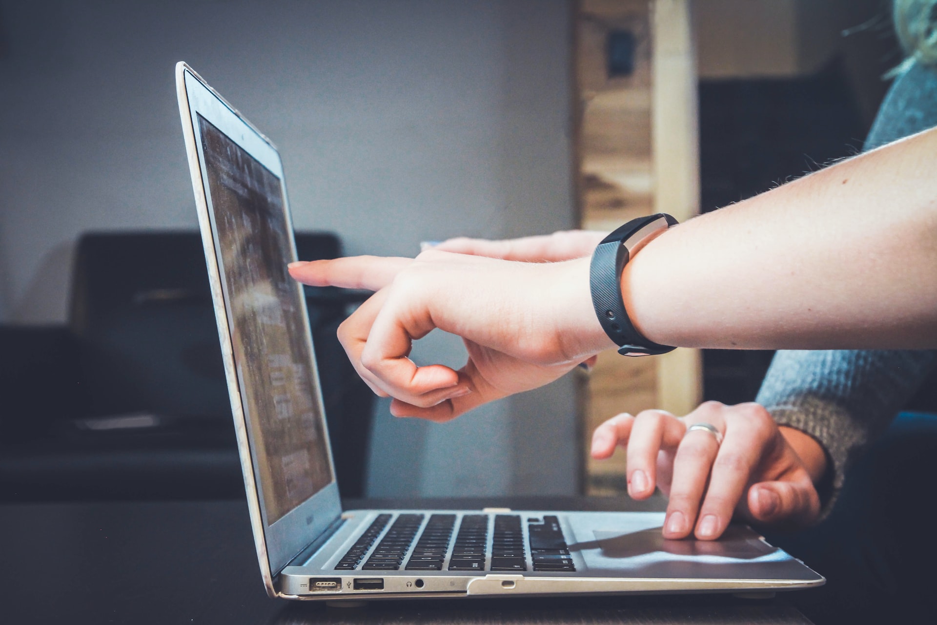 Hands pointing to screen on laptop