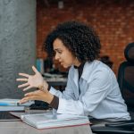 Frustrated woman gesturing to laptop