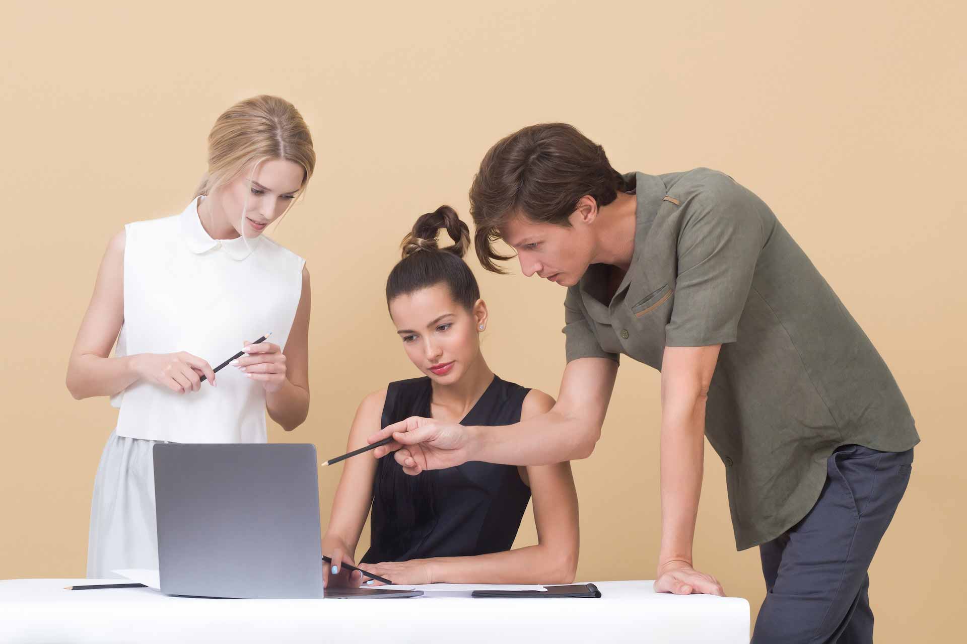 Group of three overlooking laptop